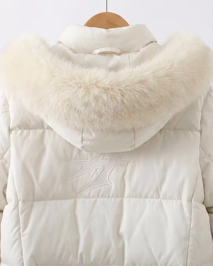A white Frekja puffer coat with a fur-trimmed hood on a hanger.
